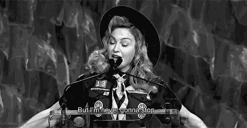 a black and white photo of a woman standing at a podium with a microphone .