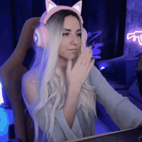 a woman wearing a pair of pink headphones with cat ears