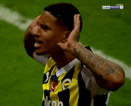 a soccer player wearing a yellow and black jersey with the word nk on it