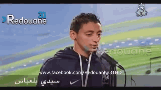 a man is singing into a microphone with the words redouane 31 on the bottom