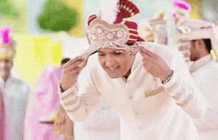 a man wearing a turban is adjusting his hat