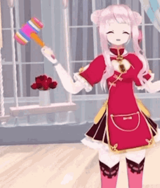 a girl in a red dress is holding a colorful mallet .