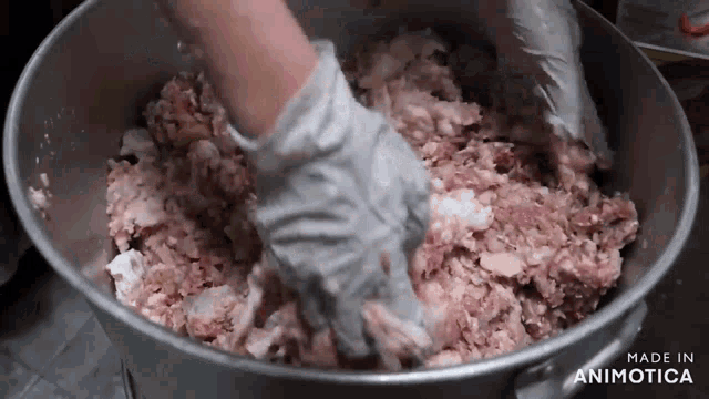a person is mixing meat in a bucket that says made in animatica on the bottom