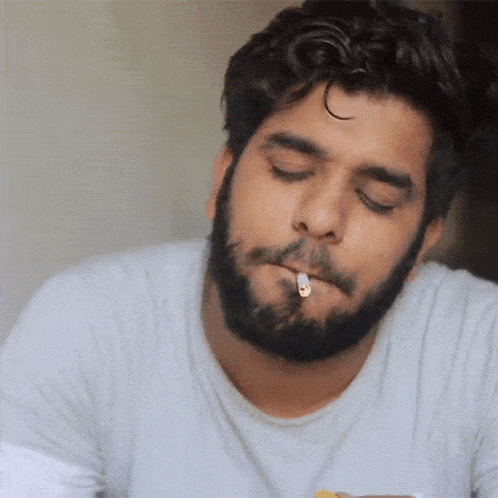 a man smoking a cigarette with his eyes closed