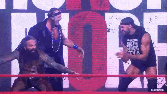 a group of wrestlers are standing in a ring and one of them is wearing a shirt that says " boston strong style "