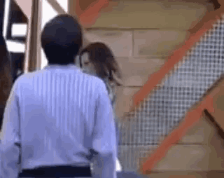 a man and woman are standing next to each other in front of a staircase .