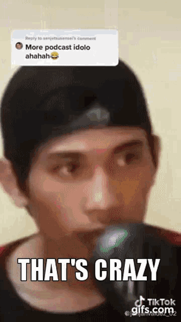 a man is singing into a microphone with the words `` that 's crazy '' written on the bottom .