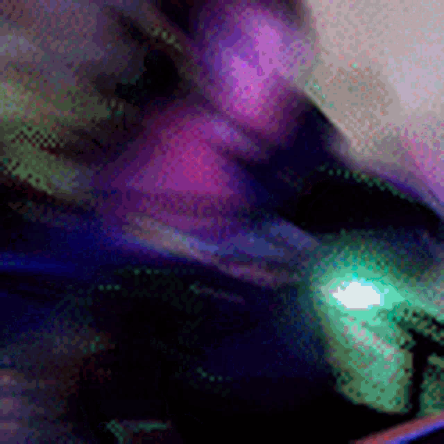 a blurry picture of a person 's face with a green light in the background