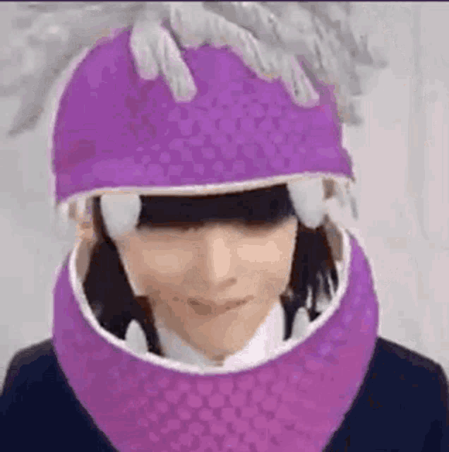 a person wearing a purple hat with a mouth open and a purple scarf around their neck .