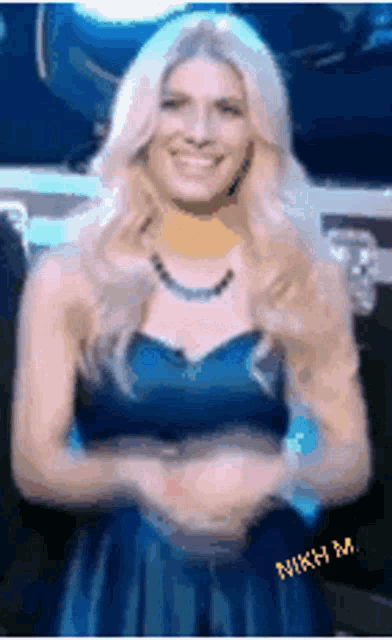 a woman in a blue dress is smiling with the name nikki written on the bottom