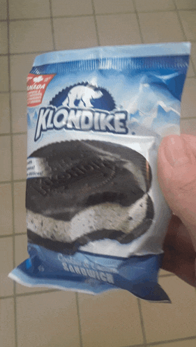 a person is holding a klondike ice cream sandwich