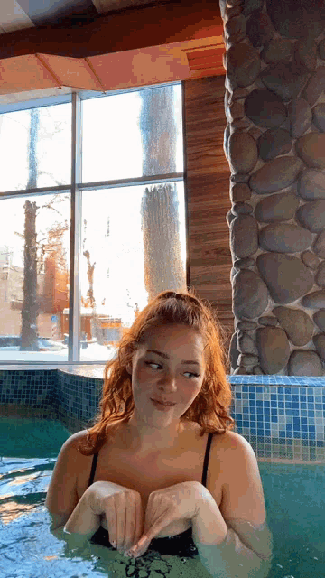 a woman in a bathing suit is in a pool