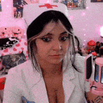 a woman in a nurse costume is sitting in front of a computer and looking at the camera .