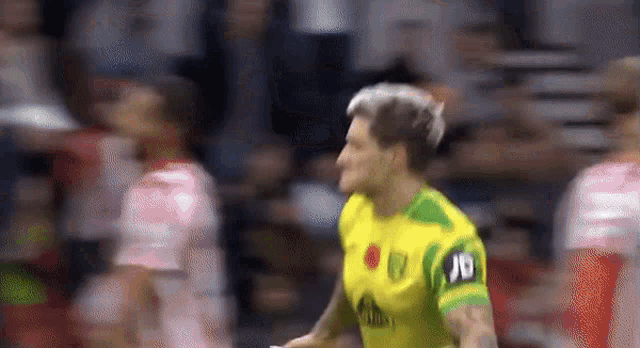 a soccer player wearing a yellow and green jersey with the number 10 on the back