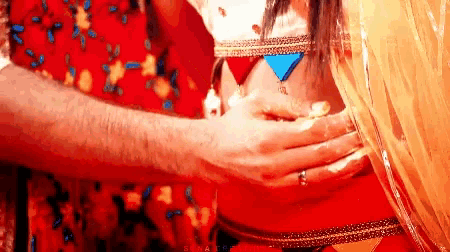 a man is touching a woman 's stomach with his hand .