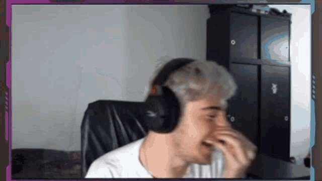 a man wearing headphones is covering his nose