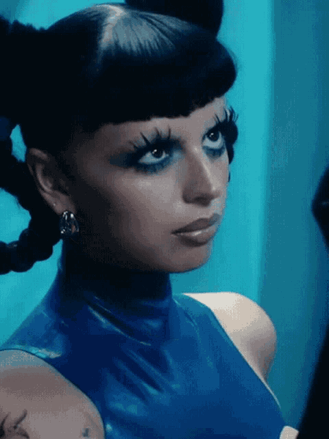 a close up of a woman 's face in a blue dress
