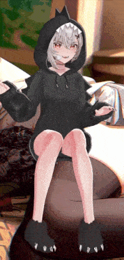 a girl in a shark hoodie is sitting on a bean bag