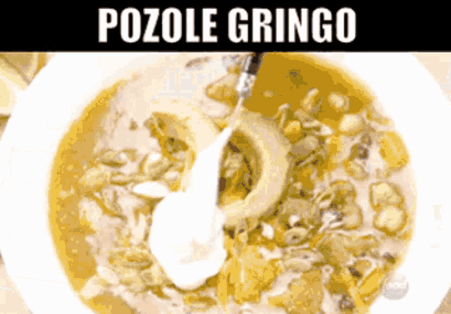 a close up of a bowl of pozole gringo soup with a spoon in it