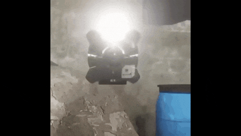 a light is shining on a blue barrel in a dark room .