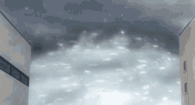 a building with snow falling on it and a dark sky