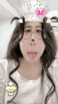 a woman wearing a chef 's hat and glasses sticking her tongue out