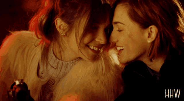two women are kissing and the word hw is on the bottom of the picture