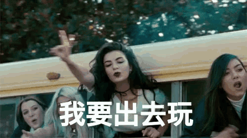 a group of girls are riding on a school bus and one of them is throwing a frisbee out the window .