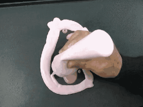a person is holding a bottle of pink slime and making a drawing on a black surface .