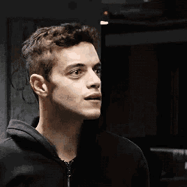 a close up of a man 's face with a black hoodie on