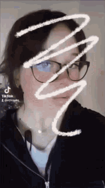a woman wearing glasses and a fork in her mouth is making a funny face .