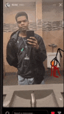 a man is taking a selfie in a bathroom mirror