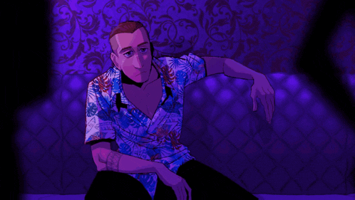 a man in a hawaiian shirt is sitting on a purple couch