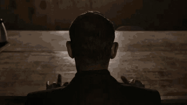 the back of a man 's head is shown in a dark room