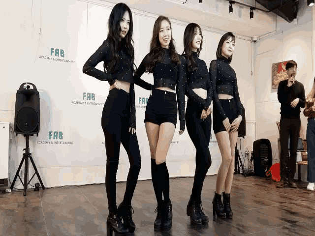 four women stand in front of a sign that says fab