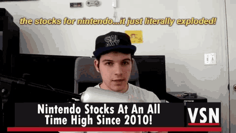 a man sitting in front of a screen that says nintendo stocks at all time high since 2010