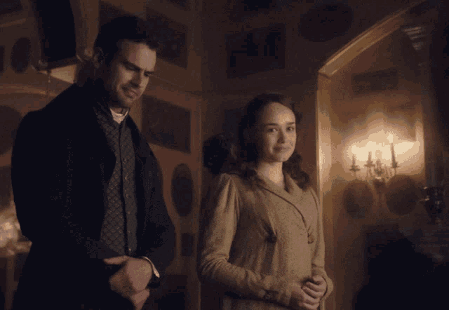 a man and a woman are standing next to each other in a room