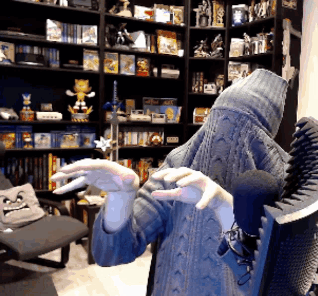 a person wearing a blue sweater with a hood on their head