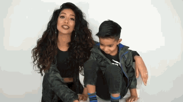 a woman and a boy are sitting next to each other .