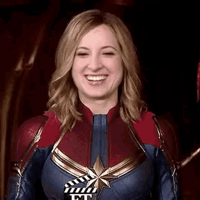 captain marvel is smiling while wearing a superhero costume .