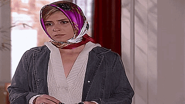 a woman wearing a purple scarf around her head and a denim jacket