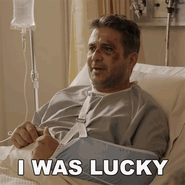 a man with a broken arm is laying in a hospital bed with the words i was lucky above him