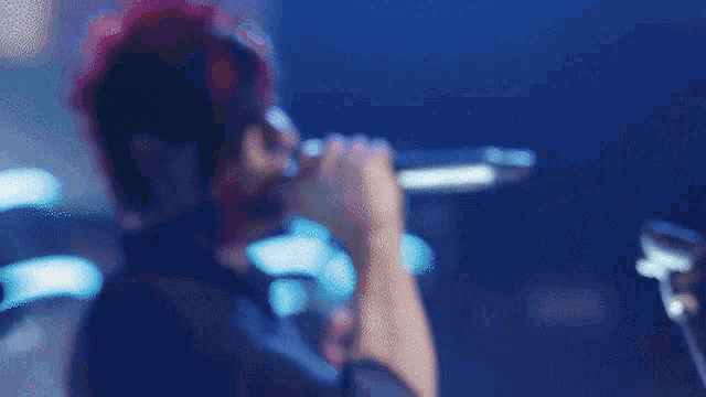 a man singing into a microphone with red hair