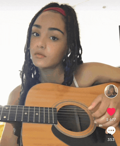 a girl with dreadlocks is holding an acoustic guitar with a selfie of another girl behind her
