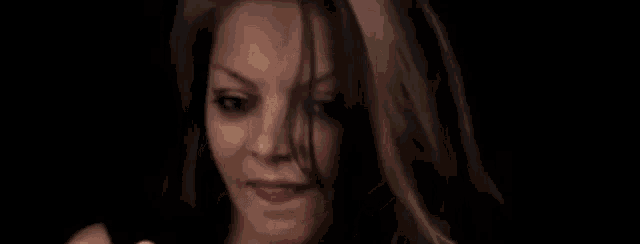 a close up of a woman 's face with her eyes closed in a dark room .