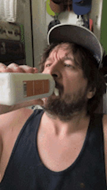 a man with a beard drinking from a bottle