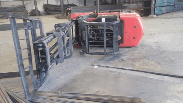 a red and black forklift is sitting on a concrete floor