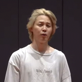 a young man with blonde hair is wearing a white t-shirt that says sega house d on it .
