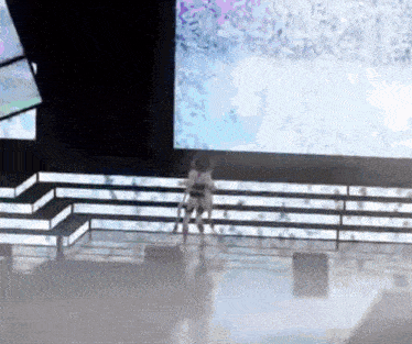 a woman in a white dress is standing on a stage