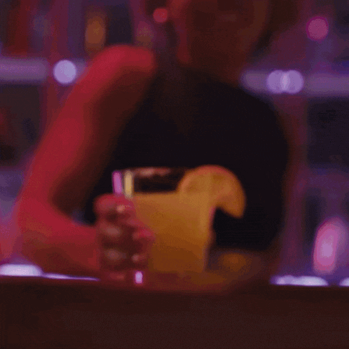 a woman with a ponytail is smiling and holding a cup of coffee